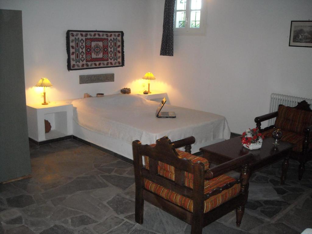 1 dormitorio con 1 cama con mesa y 2 sillas en Youth Ηostel Archipelagos - semi basement studio at Possidonia, en Ano Syros