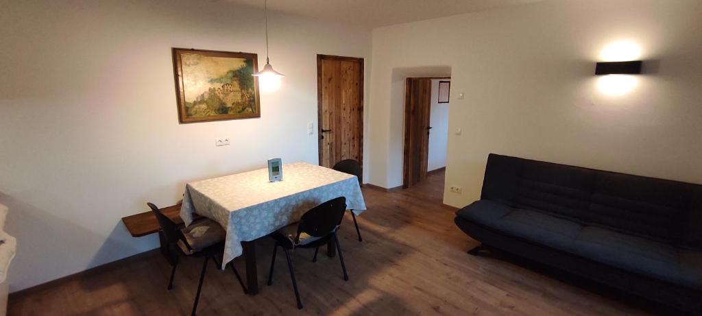 - un salon avec une table, des chaises et un canapé dans l'établissement Appartements Steffila, à Sand in Taufers