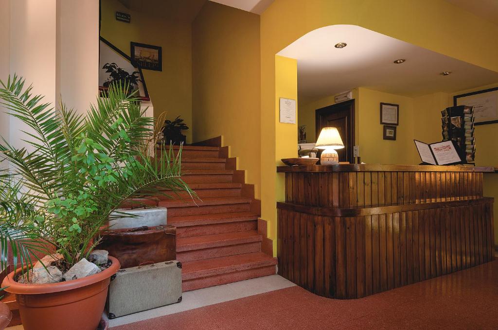 a lobby with stairs and potted plants and a desk at Arcea Mirador de Cabrales in Poncebos