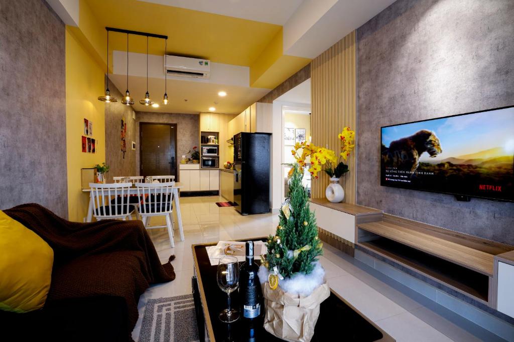 a living room with a tv on a wall at Tony Apartment Soho Q1 in Ho Chi Minh City