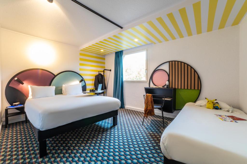 サン・ドニにあるibis Styles Paris Saint Denis Pleyelのベッド2台と窓が備わるホテルルームです。