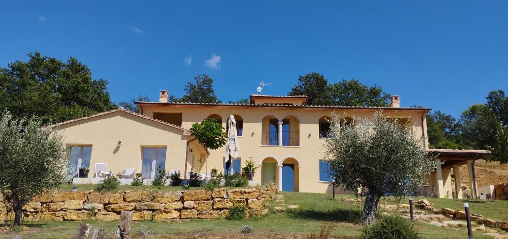 een groot huis met een stenen muur bij Col di Pietra in Giuncarico