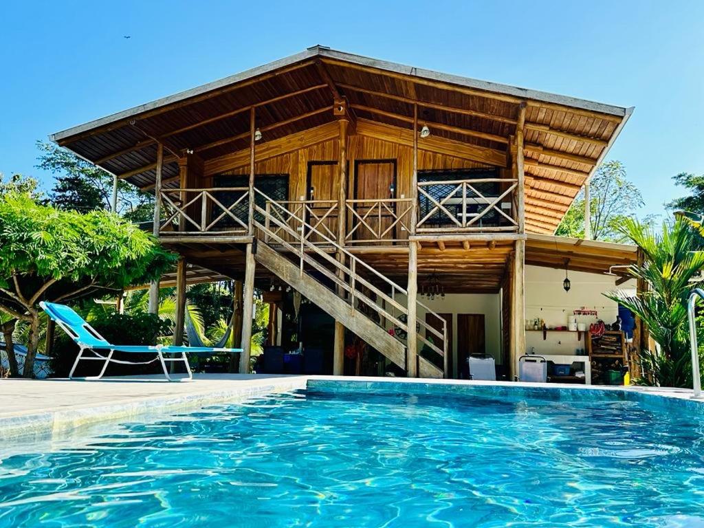 a house with a balcony and a swimming pool at Casa Gratitud in Paquera