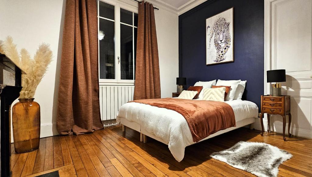 - une chambre avec un lit aux murs bleus et une fenêtre dans l'établissement Appartement tout équipé - Centre-ville EPERNAY, à Épernay