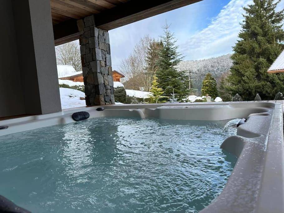 a jacuzzi tub in a house with snow at Chalet Louléa - Luxueux, au calme avec Spa in Xonrupt-Longemer