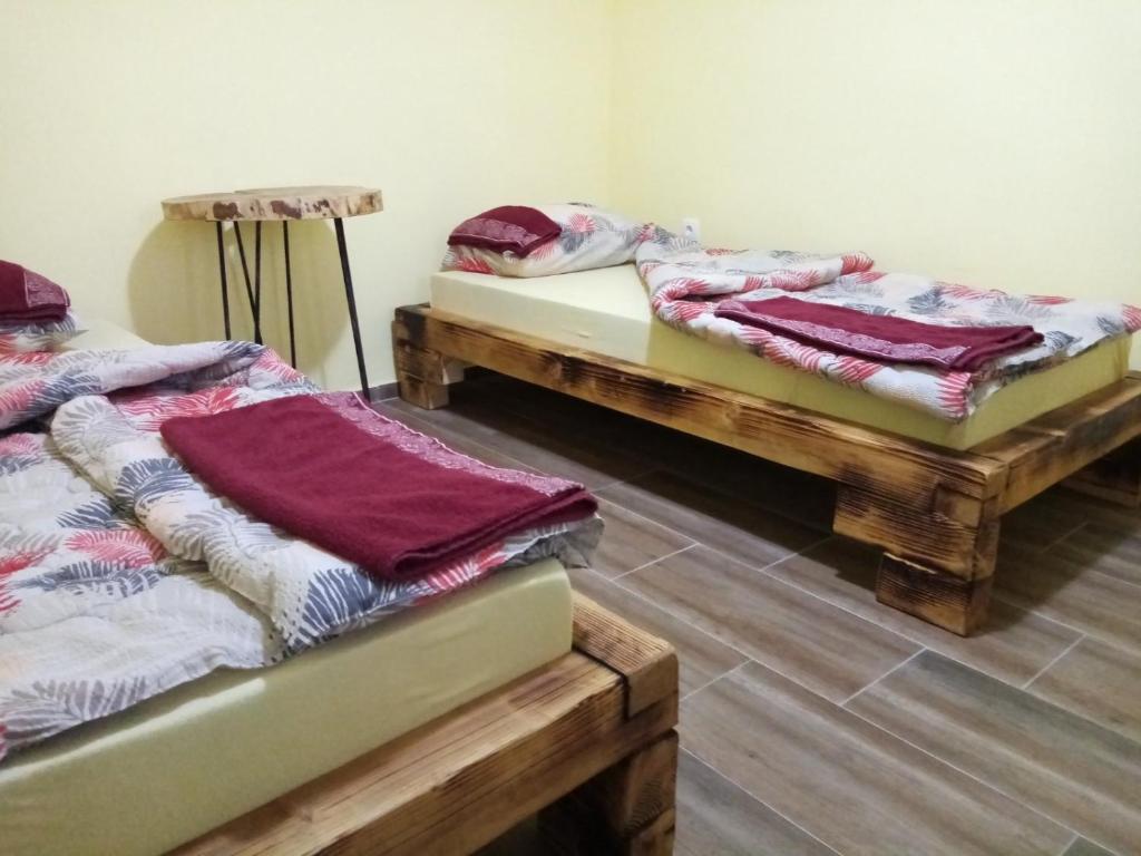 two beds sitting in a room with towels on them at Seosko domaćinstvo-Nedodjija in Apatin