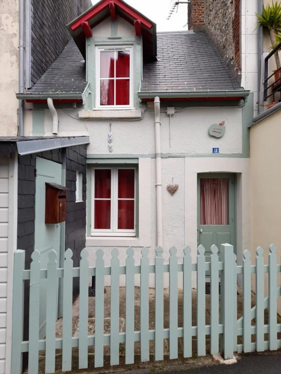 een wit hek voor een huis bij La P'tite Normande in Villerville