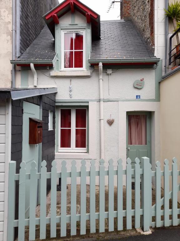 a white picket fence in front of a house at La P'tite Normande in Villerville