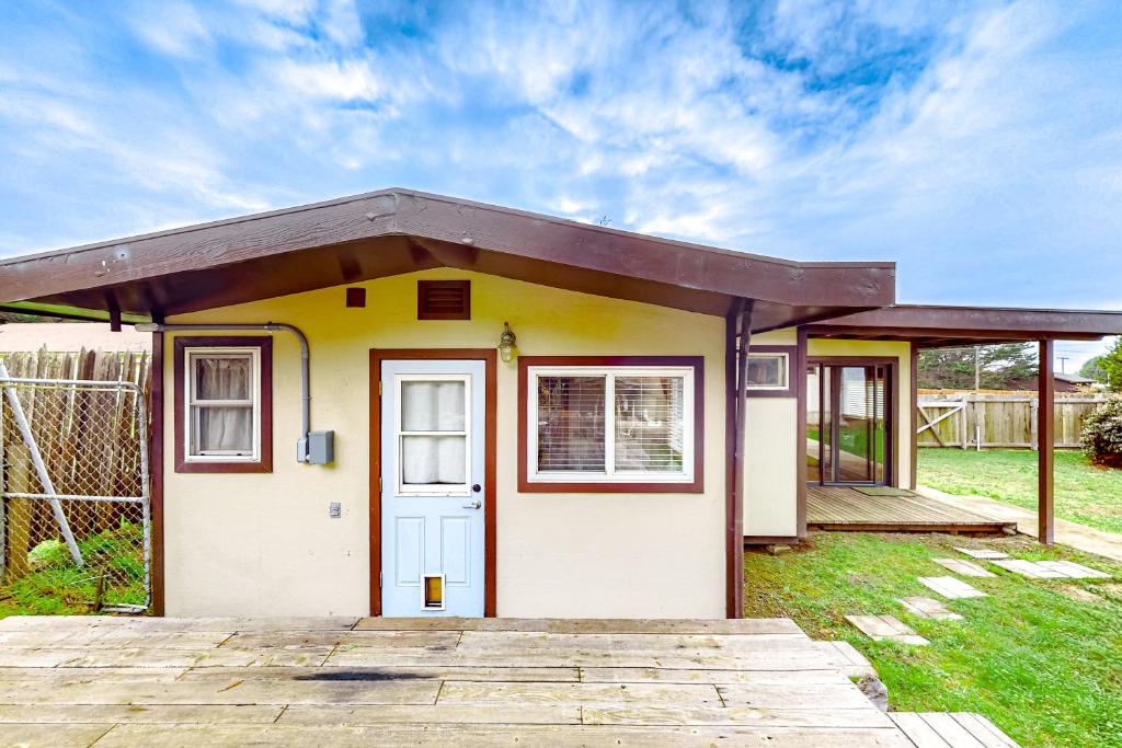 una piccola casa gialla con una porta bianca di Mill Creek Retreat a Fort Bragg