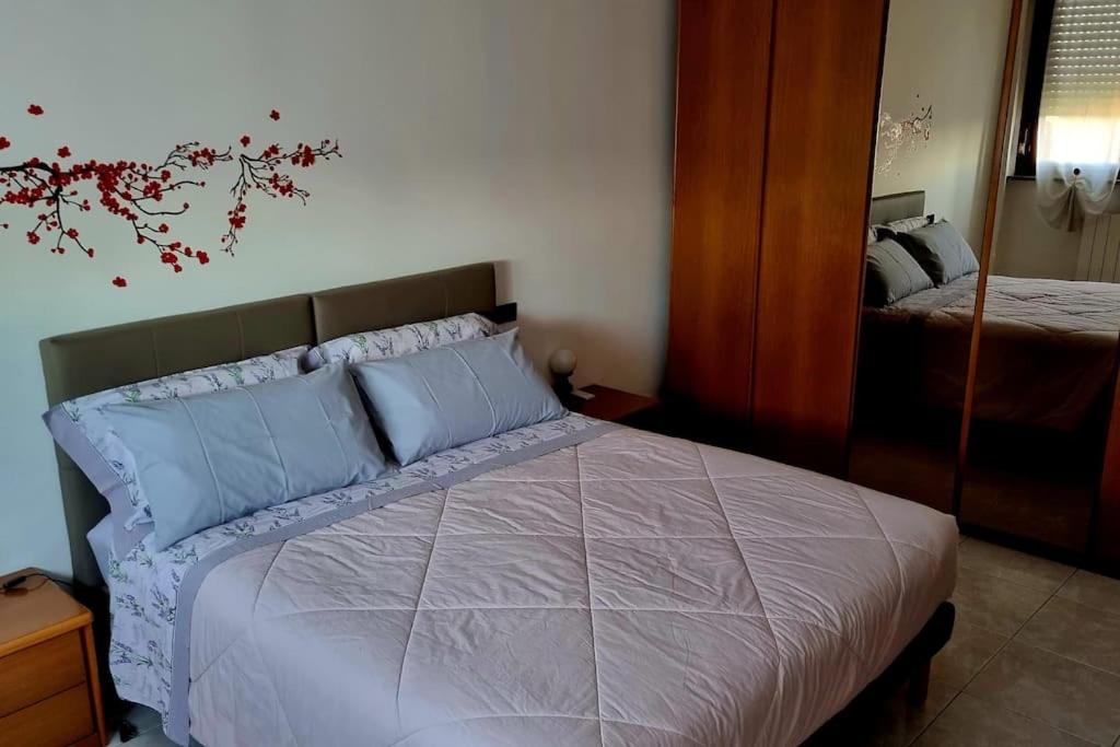 ein Schlafzimmer mit einem Bett mit blauen Kissen und einem Spiegel in der Unterkunft Appartamento Vista Panoramica in Agrate Brianza