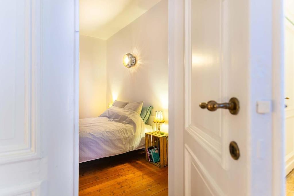 um pequeno quarto com uma cama e uma porta em Green Oasis in the city em Antuérpia