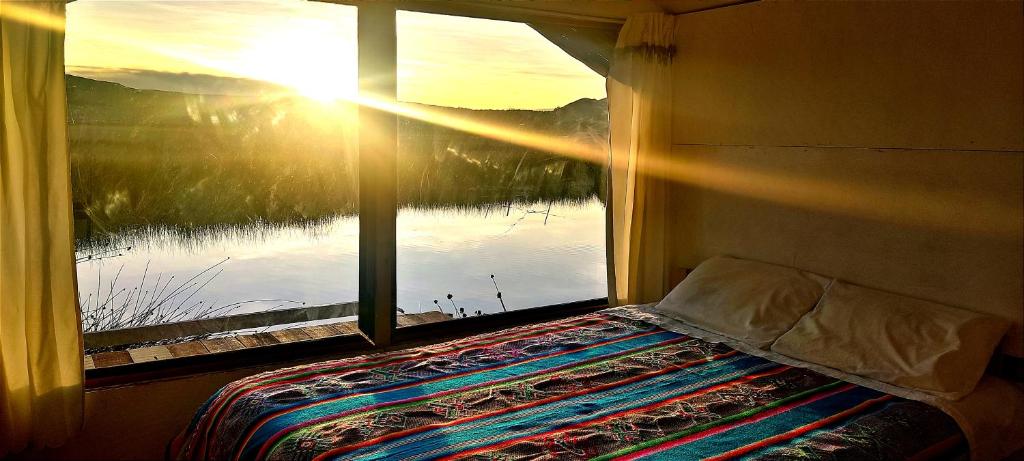 1 dormitorio con ventana y vistas al agua en Alojamiento Lago Titicaca, en Puno