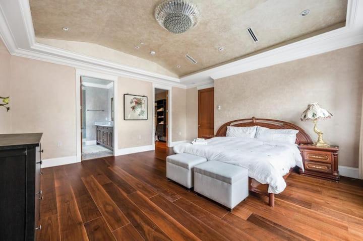 a large bedroom with a large bed and wooden floors at No. 2温哥华市中心舒适优雅独立卫生间大床套间 in Vancouver