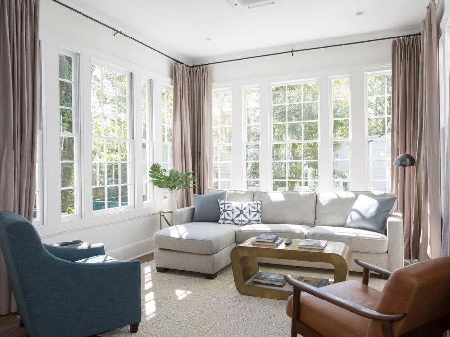 a living room with a couch and chairs and windows at Solarium at Cassa Zoe in Charleston