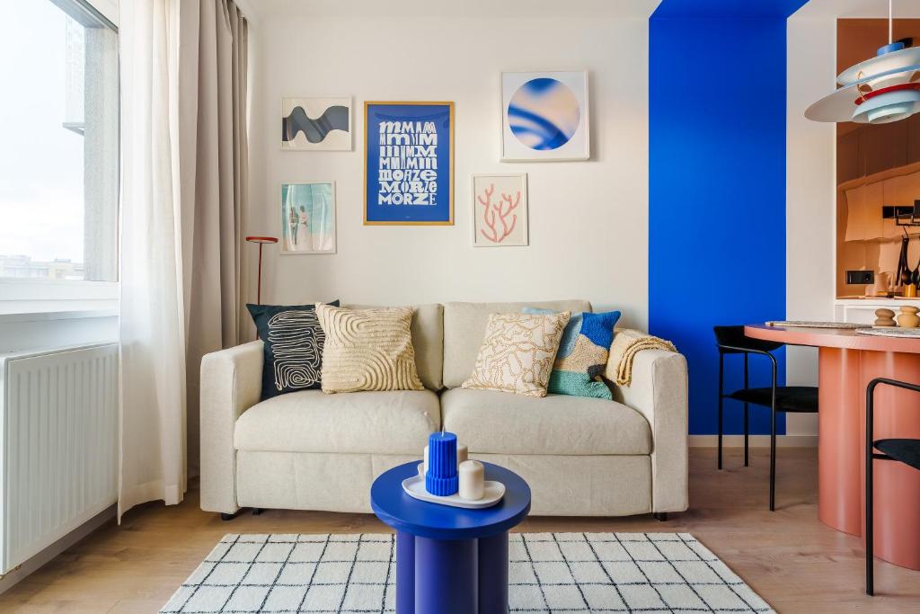 sala de estar con sofá y pared azul en Blue Marine Apartment en Kołobrzeg