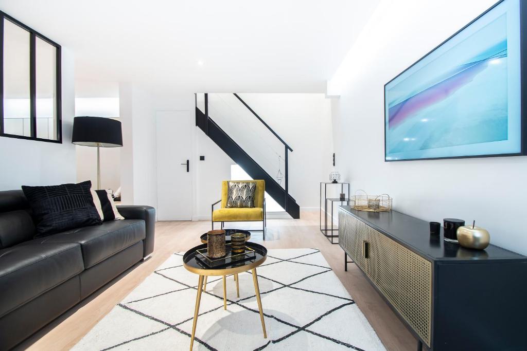 un salon avec un canapé et une télévision dans l'établissement Villa in paris - Eiffel Tower area, à Paris