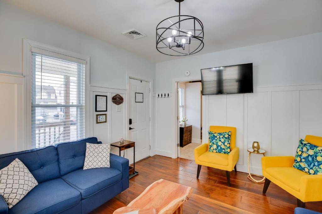 a living room with a blue couch and two yellow chairs at Atlantic City Home about 2 Mi to Ocean Casino Resort! in Atlantic City