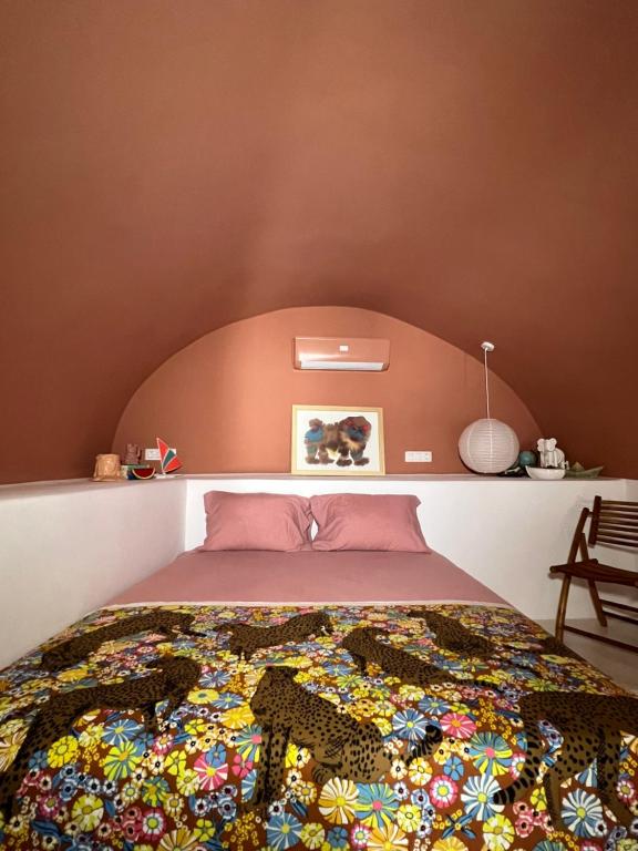a bedroom with a bed with a colorful blanket on it at IANUA Casa per Viaggiatori in Astypalaia