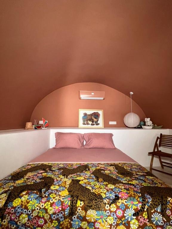 una camera da letto con un letto con una coperta colorata di IANUA Casa per Viaggiatori a Astypalaia Town