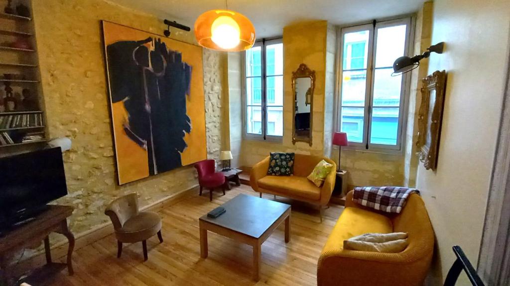un salon avec un canapé, des chaises et une télévision dans l'établissement Burdigala Homes - Appart du Vieux Marché, à Bordeaux