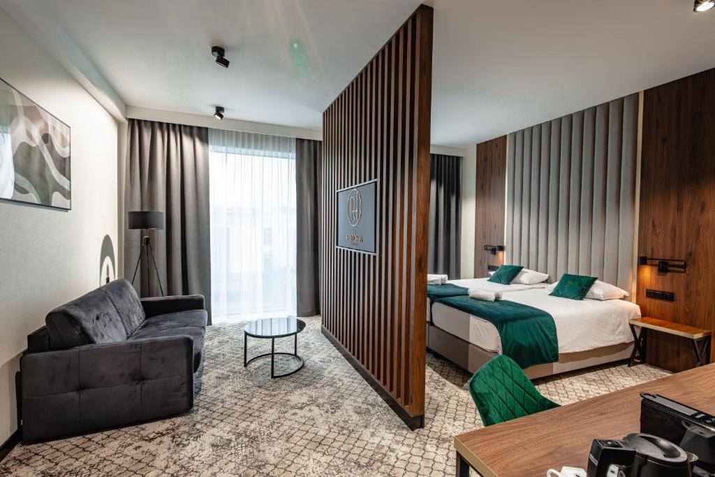 Habitación de hotel con cama y sofá en Restoria Hotel***, en Radzyń Podlaski