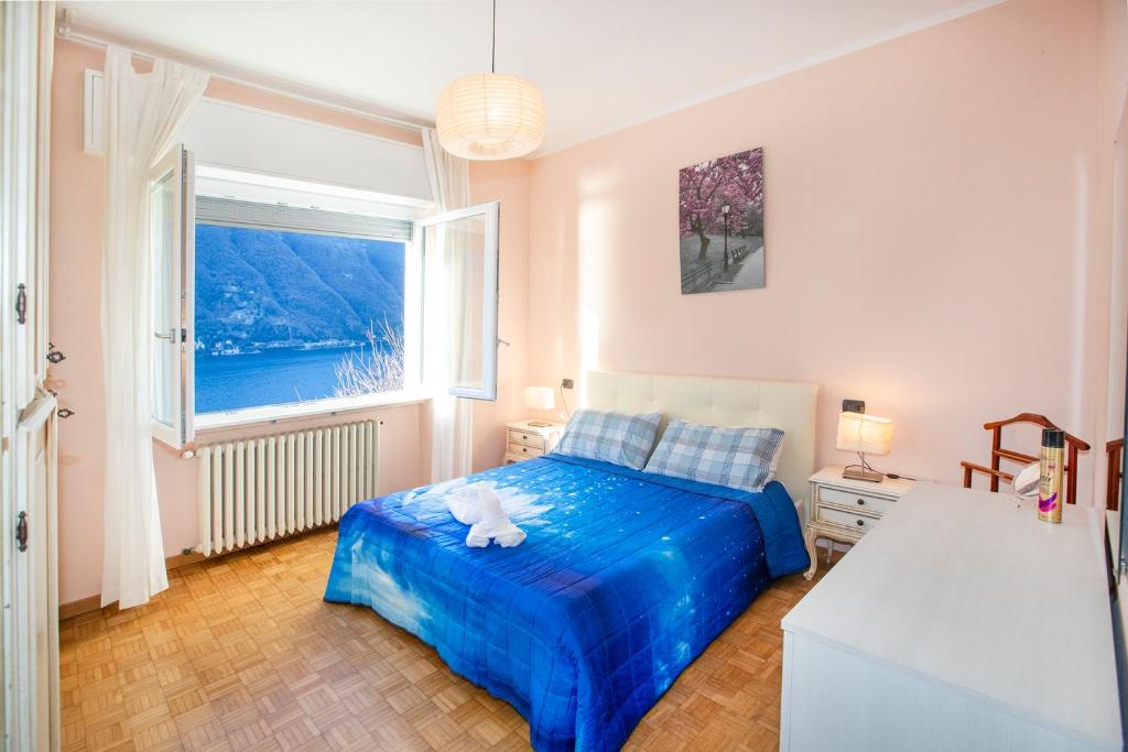 ネッソにあるCasa Vacanza LERAのベッドルーム(青いベッド1台、大きな窓付)