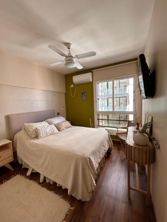 um quarto com uma cama e uma televisão de ecrã plano em Hermoso y comodo departamento em Buenos Aires