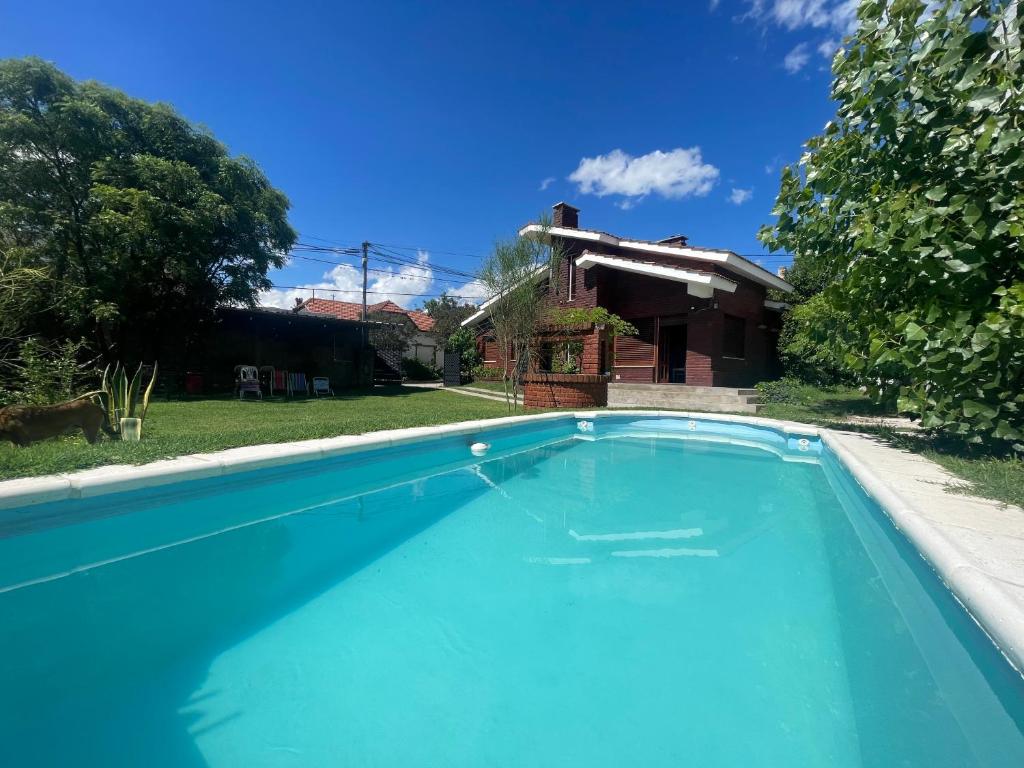 a swimming pool in front of a house at Casa Quinta La Falda Cordoba in La Falda