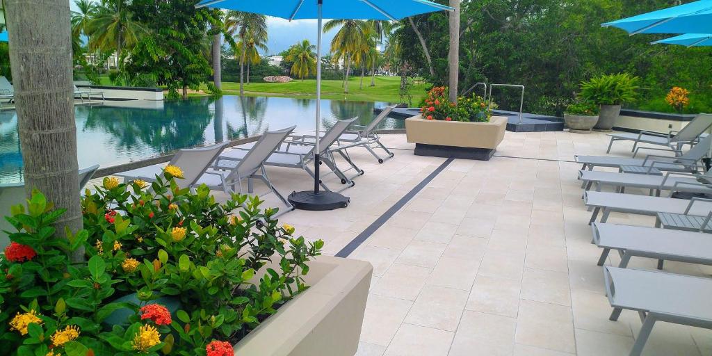 a patio with chairs and umbrellas next to a pool at Vgolf Casa Bonita Vista in Puerto Vallarta