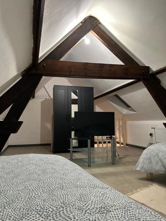 1 dormitorio con 1 cama y TV de pantalla plana en BelloHome, en La Bretagne