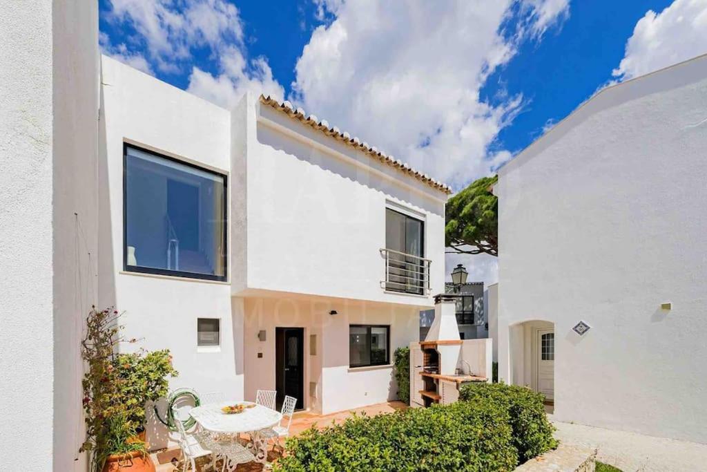 a white house with a table and chairs at Stunning 3 bed Villa in Vale do Lobo with Resort Membership 3 mins From Beach and Golf in Loulé