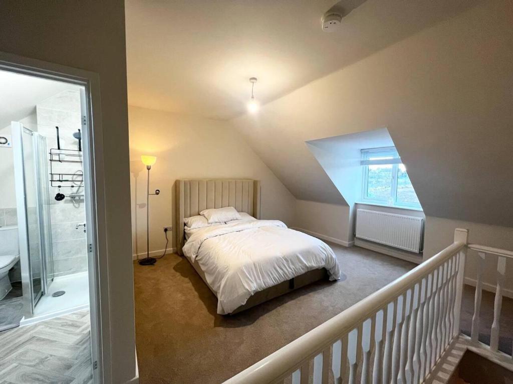 a bedroom with a large bed and a staircase at Beautiful 3-Bed House in Bradford in Bradford
