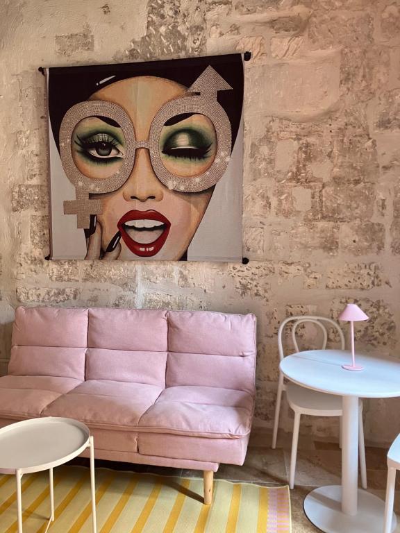 a living room with a pink couch and a painting of a woman at Pop'Arles in Arles