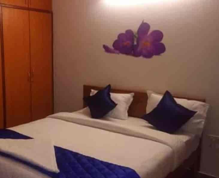 a bedroom with a bed with blue pillows and a flower on the wall at Hotel Adhunik Palace in Keonjhargarh