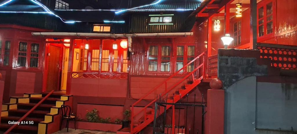 um edifício vermelho com escadas vermelhas e luzes em Bloom inn em Shillong