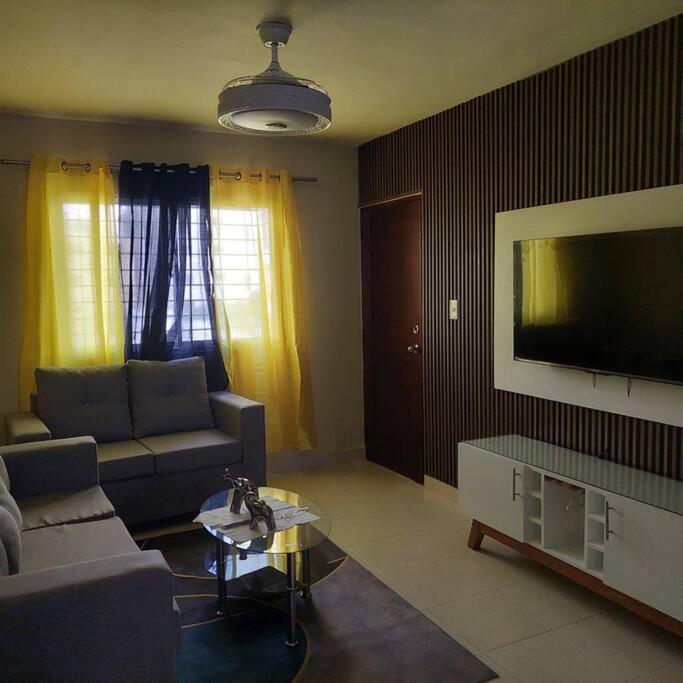 sala de estar con sofá y TV de pantalla plana en Acogedor Apartamento en Santiago en Santiago de los Caballeros