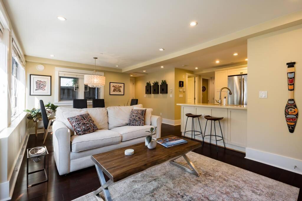 ein Wohnzimmer mit einem weißen Sofa und einem Tisch in der Unterkunft Vine & Balsam in Vancouver