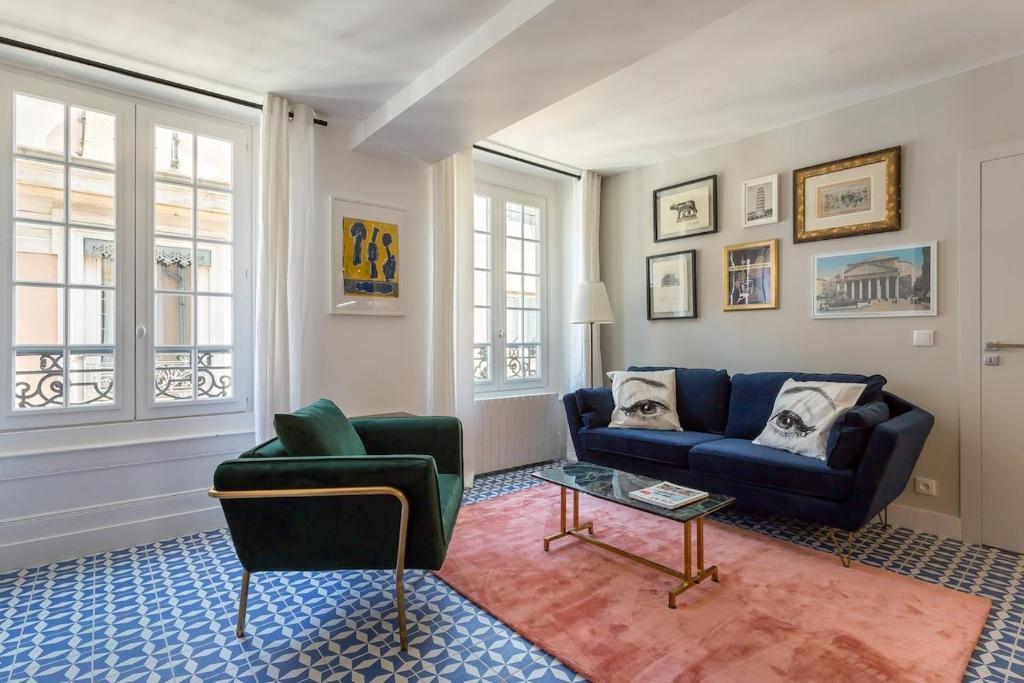 ein Wohnzimmer mit einem blauen Sofa und einem Tisch in der Unterkunft Strada - magnifique appartement proche Opéra in Lyon