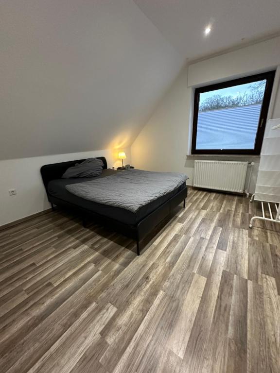 een slaapkamer met een bed en een groot raam bij Schöne, moderne Wohnung mit Waldblick & Parkplatz in Melle