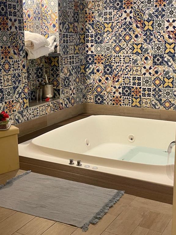La salle de bains est pourvue d'une baignoire blanche et de carrelage. dans l'établissement San Nicola Suite & mini apartment, à Sorrente