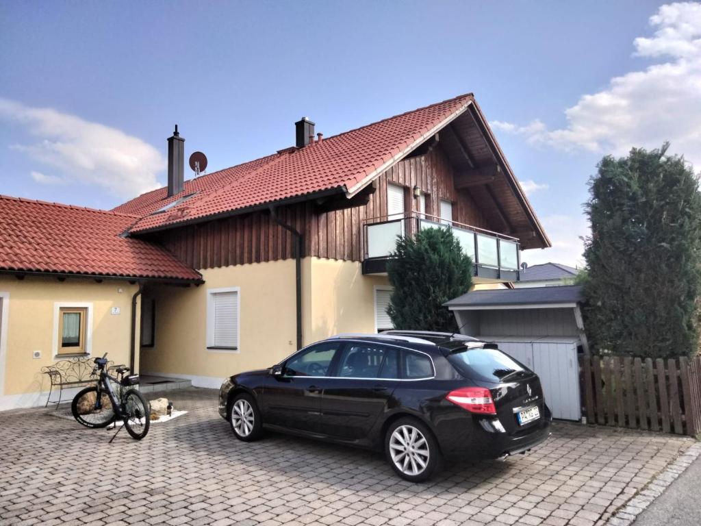 基爾夏姆的住宿－Rudis Ferienwohnung，停在房子前面的一辆黑色汽车