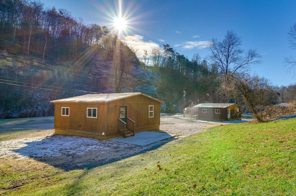 a small house in a field with the sun in the background at Peaceful Beattyville Cabin Near Red River Gorge! in Beattyville