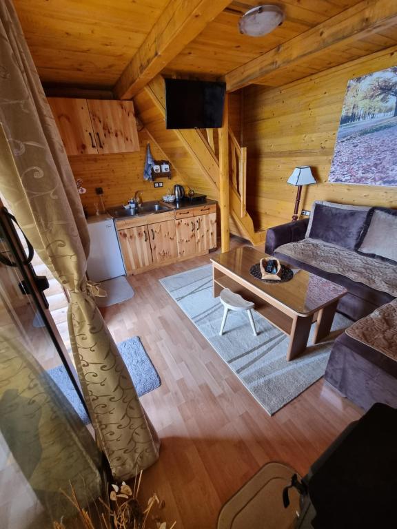 un soggiorno con divano e tavolo in una cabina di Livari Rooms Exclusive Chalet a Bar