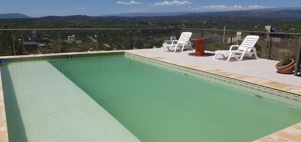 una piscina con sillas y una mesa en el balcón en Estancia de Campo en Estancia Vieja