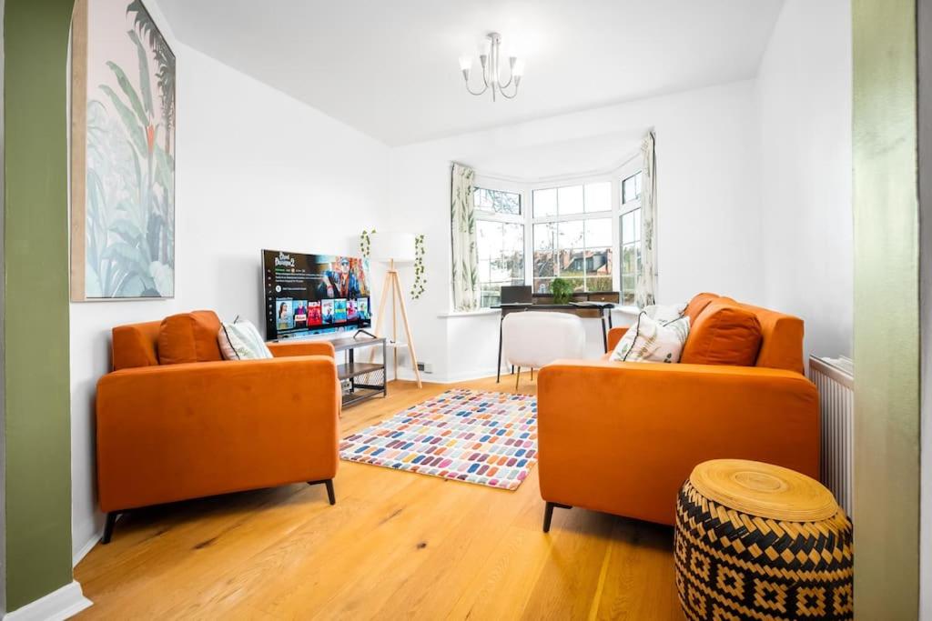 a living room with two orange couches and a television at The Home on The Hill in Birmingham