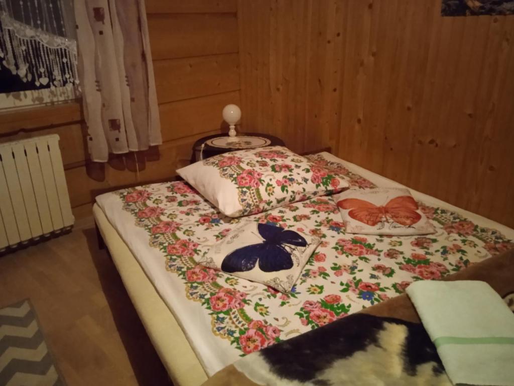 a bed with two pillows on top of it at Wypoczynek u Agnieszki in Ochotnica Górna