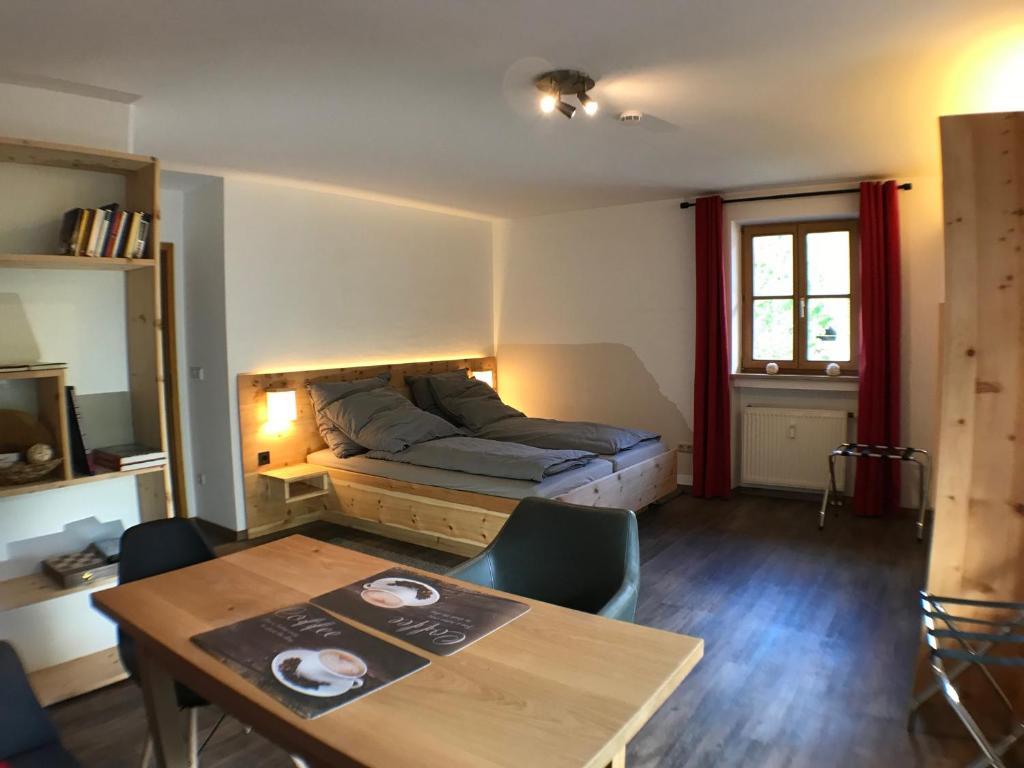 a room with a bed and a table with chairs at Apartment Kofel Aussicht in Oberammergau
