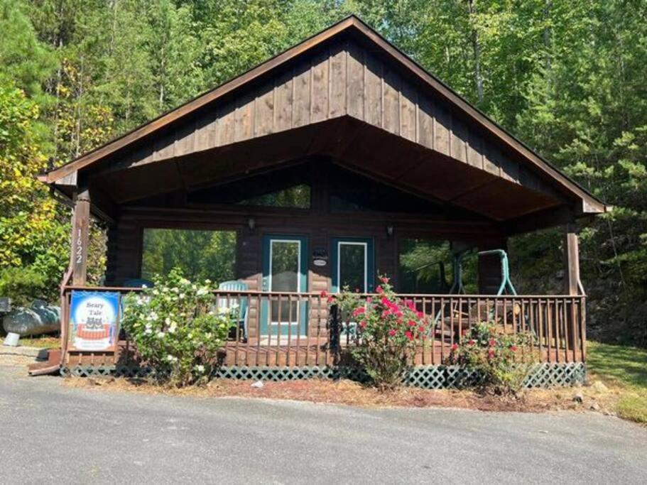 a small cabin with a large porch in the woods at Beary Tale! Your happily ever after starts here! in Sevierville