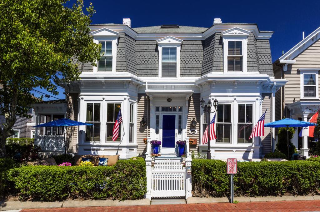 Uma casa com bandeiras americanas à frente. em Prince Albert Guest House, Provincetown em Provincetown