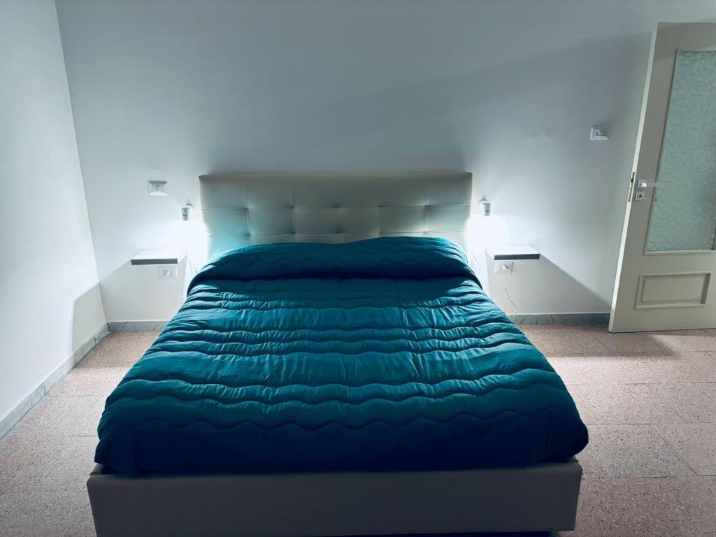 una camera con letto e piumone blu di Dimora Nonna Rosa ad Aversa